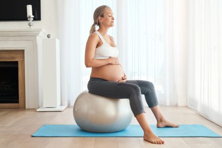 Pregnant Woman Sitting On Yoga Ball